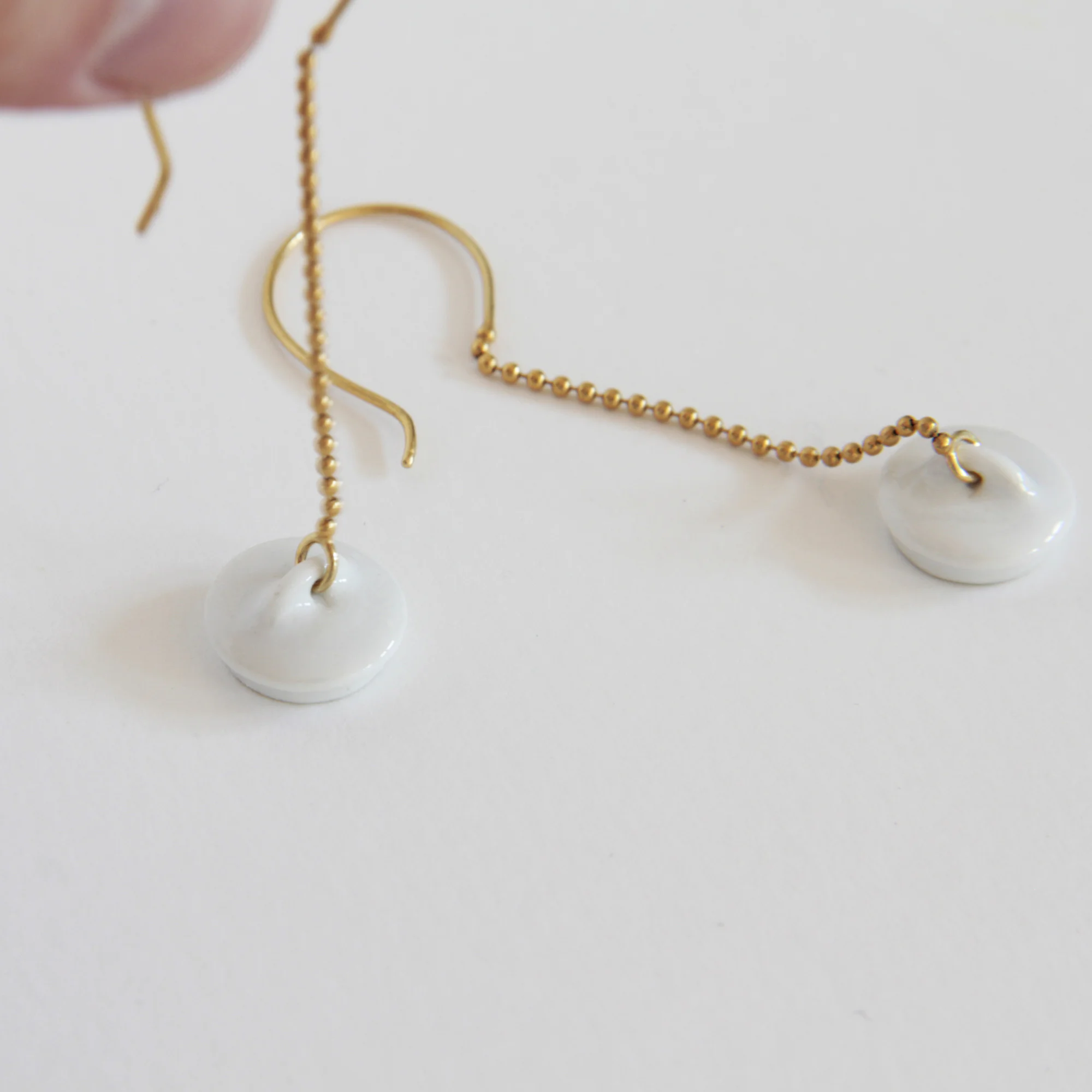 Pendientes dorados y porcelana Tapón
